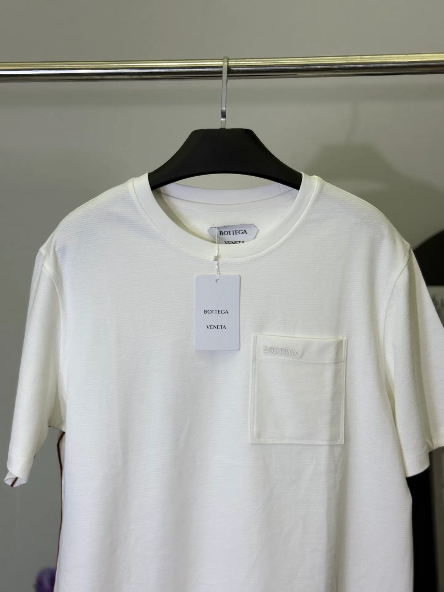 💋 Bottega Veneta Pocket Embroidered White T-shirt puts the relaxed Italian minimalist aesthetics into this refreshing white T-shirt. The iconic pocket design is paired with low-key embroidery, and the contrasting webbing details on the side are low-key yet rich in texture on a pure white background. It is a taste that knowledgeable people can get at a glance. Select heavyweight high-count cotton material, which is as soft as clouds, draped and stylish, and the upper body has an "expensive sense of relaxation". The neat and slightly loose version is suitable for daily outings and light business commuting. A white T-shirt can keep you cool and decent in all occasions. M-3XL